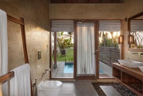 a bathroom with a toilet and a sink and a mirror at Ayana Sea in Wadduwa