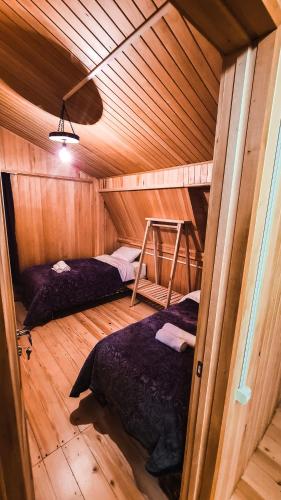 a room with two beds in a wooden cabin at Feel Funny House in Kʼveda Marghi
