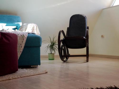a chair and a couch in a living room at Altavista mountain apartment in Samokov