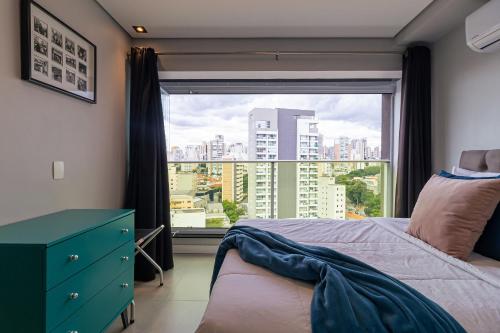 a bedroom with a window with a view of a city at Vossa Bossa VN Turiassu in Sao Paulo