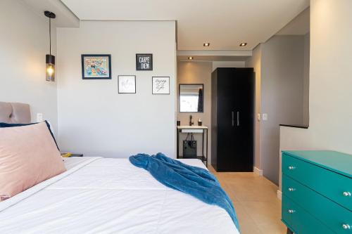 a bedroom with a white bed and a blue dresser at Vossa Bossa VN Turiassu in Sao Paulo