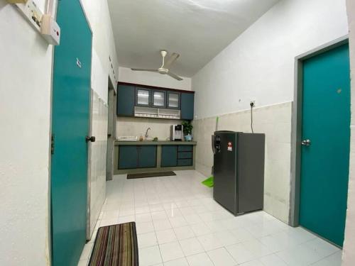 eine Küche mit blauen Schränken und einem grünen Kühlschrank in der Unterkunft Homestay Bandar Temerloh Wi-Fi Netflix Smart TV in Temerloh