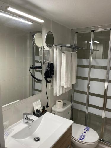 a bathroom with a sink and a toilet and a mirror at Casas La Aldea Suites Plaza in San Nicolás