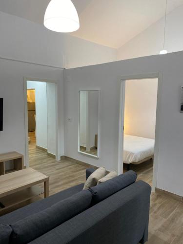 a living room with a blue couch and a bed at Casas La Aldea Suites Plaza in San Nicolás