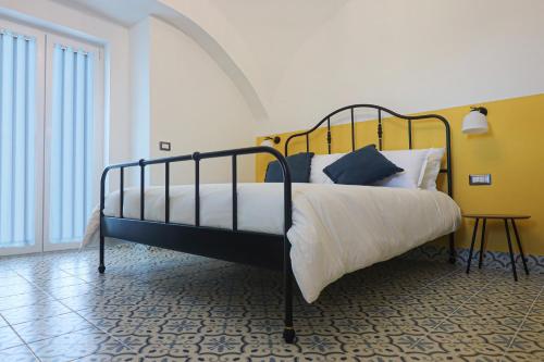 Schlafzimmer mit einem Bett mit weißer Bettwäsche und blauen Kissen in der Unterkunft La Casa del Bosco - Unique two storey House with garden in Neapel