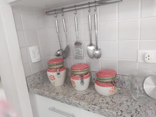 eine Küchentheke mit vier Gläsern und Küchenutensilien in der Unterkunft APARTAMENTO RIVIERA DE SÃO LOURENÇO in Riviera de São Lourenço