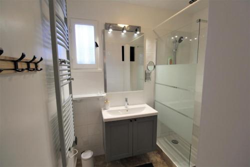 a white bathroom with a sink and a shower at Les Bastidons de L'Isle - Le Saint-Julien - 3 étoiles in LʼIsle-sur-la-Sorgue