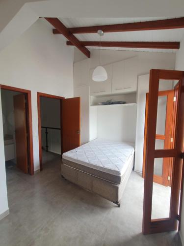 ein Schlafzimmer mit einem Bett in einem weißen Raum in der Unterkunft Casas a 5 min do Centro Histórico in Paraty