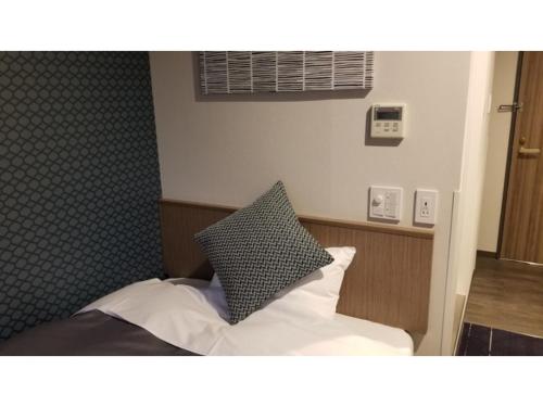a bedroom with a bed with a pillow on it at Sun Royal Utsunomiya - Vacation STAY 02483v in Utsunomiya