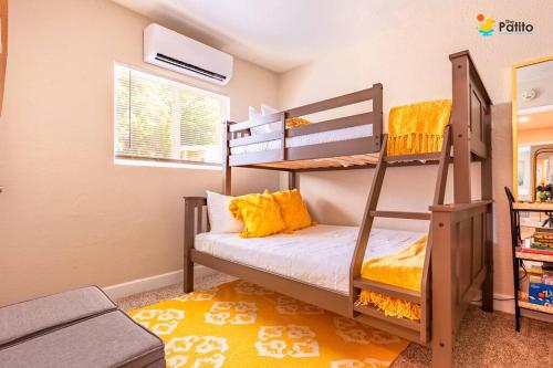 a bedroom with two bunk beds and a yellow rug at The Patito: Walk to the Zoo, Cafes and Restaurants in Albuquerque