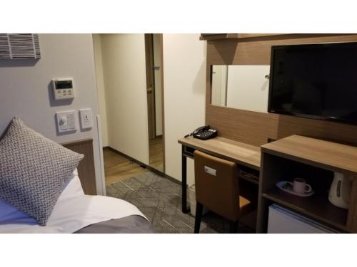 a bedroom with a desk with a television and a bed at Sun Royal Utsunomiya - Vacation STAY 02534v in Utsunomiya