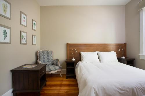 a bedroom with a bed and a chair at Lakehouse Inn in Lee