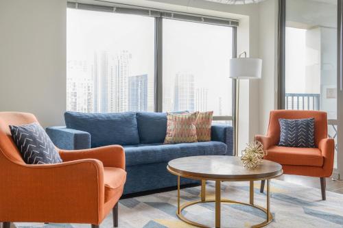 a living room with a blue couch and two chairs at Kasa South Loop Chicago in Chicago