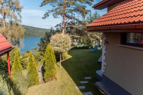 a backyard with a view of a lake and a house at Cottage in Domaša. Chata na Domaši. in Bžany