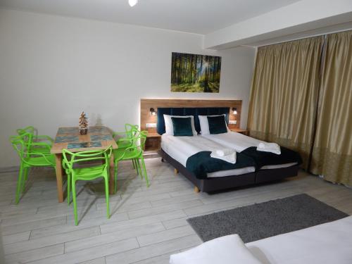a bedroom with a bed and a table and chairs at AGAT Apartament Czarna Góra in Sienna