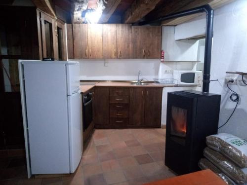 a kitchen with a white refrigerator and a stove at Apartamento Valdelinares,Casa la roca in Valdelinares