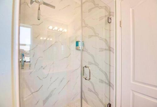 a shower with a glass door in a bathroom at NAUTILUS...ocean front cottage retreat ~ in Cudjoe Key
