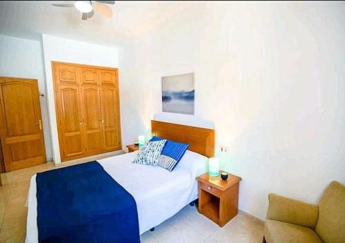 a small bedroom with a bed and a couch at Apartamento LLac,bahía de Alcudia. in Alcudia
