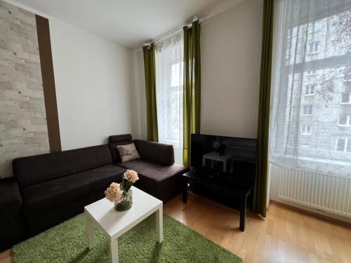 een woonkamer met een bank en een tafel bij Cozy 2-room apartment in Wenen