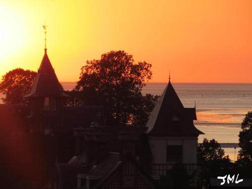 een gebouw met een zonsondergang op de achtergrond bij AUTHENTIQUE MAISON DE PECHEUR ENTRE-TERRE & MER in Saint-Valery-sur-Somme