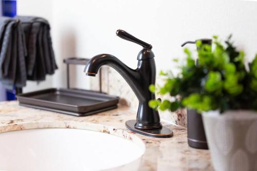 a bathroom sink with a black faucet on a counter at The Lagartija @ Old Town with King Bed in Albuquerque