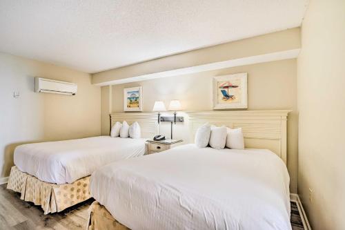 two beds in a hotel room with white sheets at Oceanfront Myrtle Beach Condo with Balcony! in Myrtle Beach