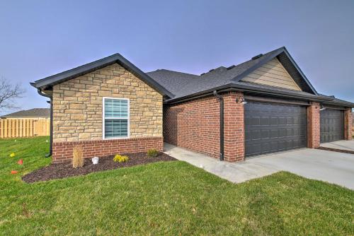 a brick house with a garage in a yard at Pet-Friendly Ozark Home with Yard and Patio in Ozark