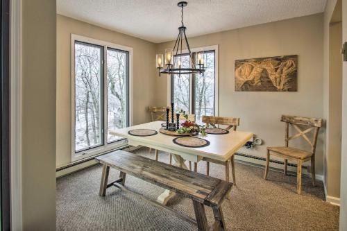 a dining room with a table and a bench and windows at Wintergreen Resort Condo Walk to Ski Lift! in Mount Torry Furnace
