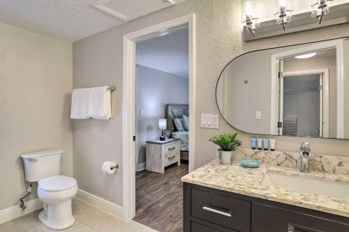 a bathroom with a toilet and a sink and a mirror at Pet-Friendly Gulfport Home Less Than 2 Mi to Beach in St Petersburg