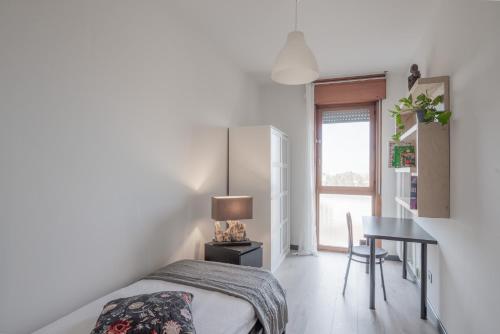 een slaapkamer met een bed, een tafel en een raam bij Cappella degli Scrovegni Grey Apartment in Padua