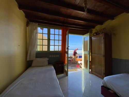 a bedroom with two beds and a view of the ocean at WEST COAST HOSTEL in Imsouane