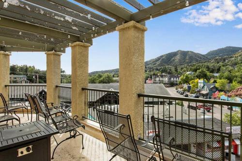 a balcony with chairs and a view of a town at The Owl's Nest @ Manitou: Mtn Views on Main Street in Manitou Springs