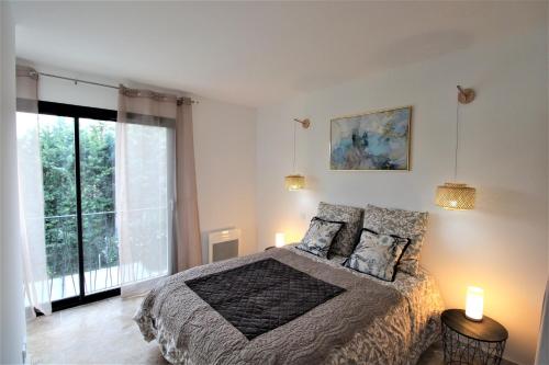 een slaapkamer met een bed en een groot raam bij Les Bastidons de l'Isle - Le Seguret - 3 étoiles in LʼIsle-sur-la-Sorgue
