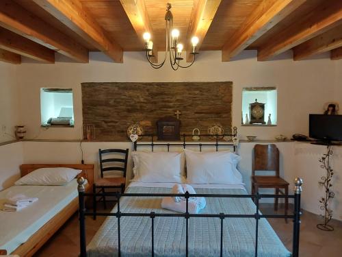 a bedroom with two beds and a chandelier at Xenia's Traditional House in Andros