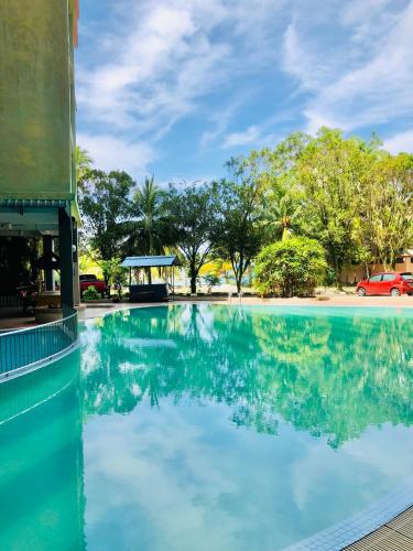 a pool at a resort with trees in the background at Homestay Legacy Kamariah Ahmad,Lumut in Lumut