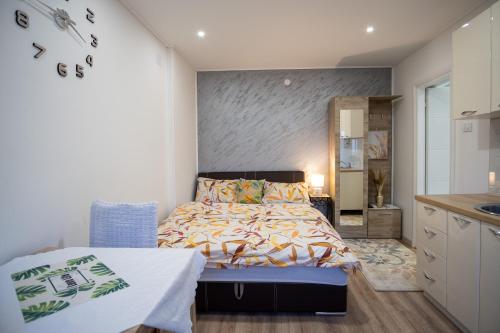 a small bedroom with a bed and a kitchen at Apartments Solar Trebinje in Trebinje