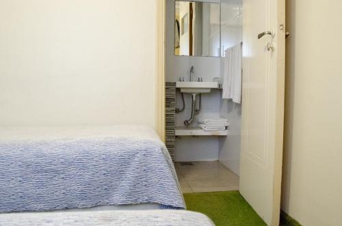 a small bathroom with a bed and a sink at Hotel King's in Mar del Plata