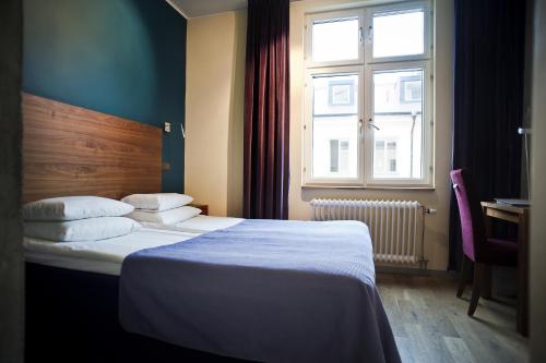 a hotel room with a bed and a window at Rex Hotel in Stockholm
