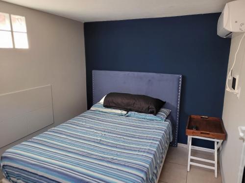 a bed in a bedroom with a blue wall at Aqua Duplex in Villa Carlos Paz