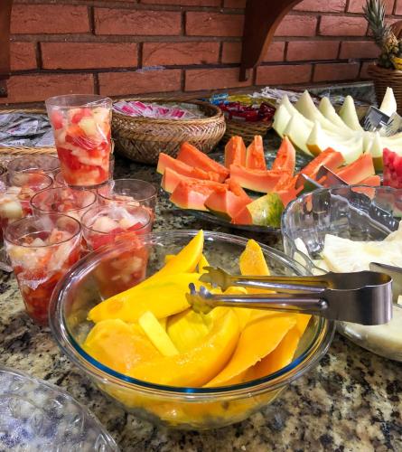 a table topped with a bowl of fruits and vegetables at Hotel Garnier in Campos do Jordão