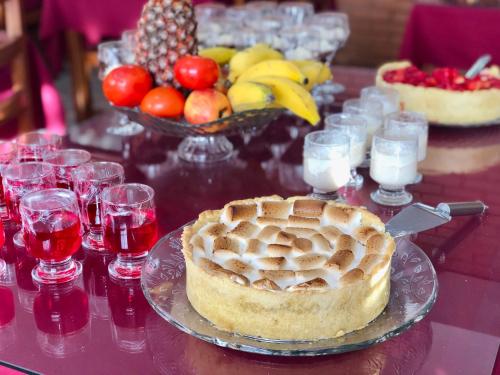 a table topped with a pie and a bowl of fruit at Hotel Garnier in Campos do Jordão
