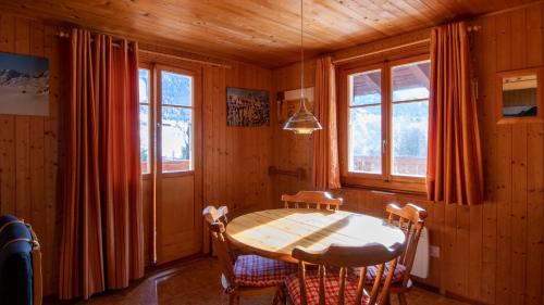 a dining room with a table and chairs and windows at Maxima in Fiesch