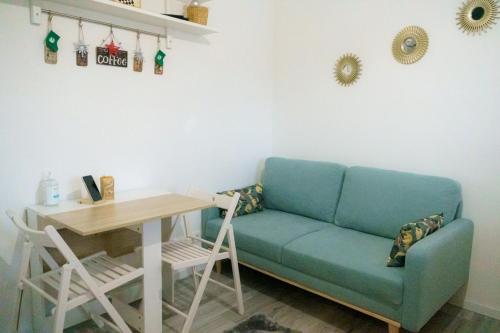 a living room with a blue couch and a table at Appartement chaleureux à Alfortville in Alfortville