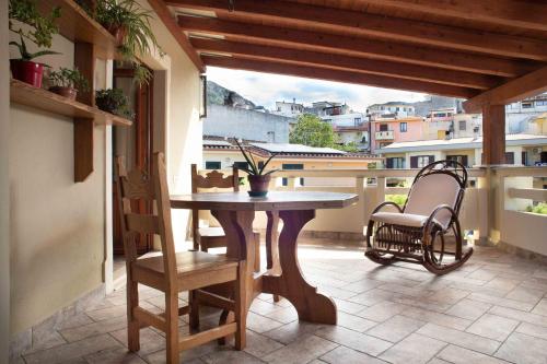 patio con mesa y sillas en el balcón en Casa Pilighitta, en Dorgali