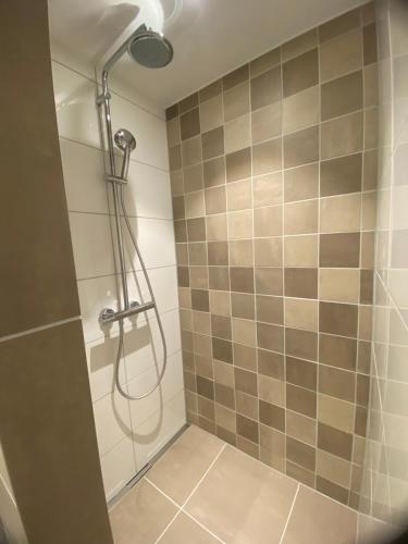 een douche met een douchekop in de badkamer bij Apartment Ella with free privat parking in Zandvoort
