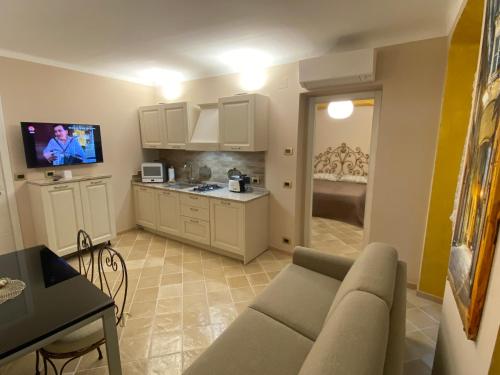 a living room with a couch and a kitchen at Casa Orefici, 4 Apartments in front of Aquarium! in Genova