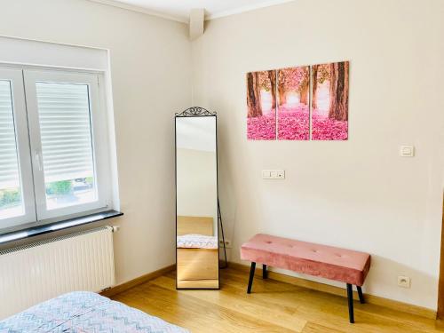 ein Ankleidezimmer mit einem Spiegel und einer rosa Bank in der Unterkunft La Villa des Coteaux - Proche Centre-ville in Lüttich
