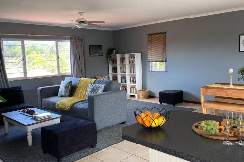 a living room with a couch and a table at The Palms 3 bedroom loft apartment in leafy suburb in Durban