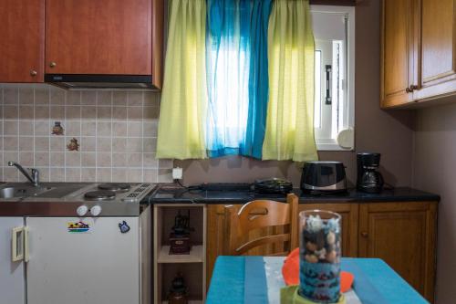 a kitchen with a sink and a table with a table at Belleza Villa in Lixouri