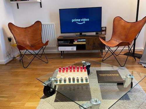 a living room with two chairs and a tv at Central London - The Shoreditch, Angel, Old Street Apartment in London